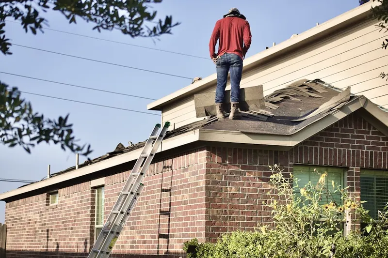 Professional roofer working on a residential roof in Village Green Neighborhood